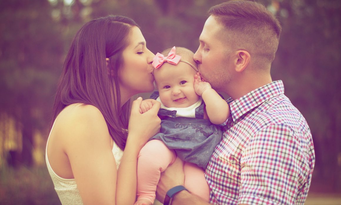 Family kissing baby